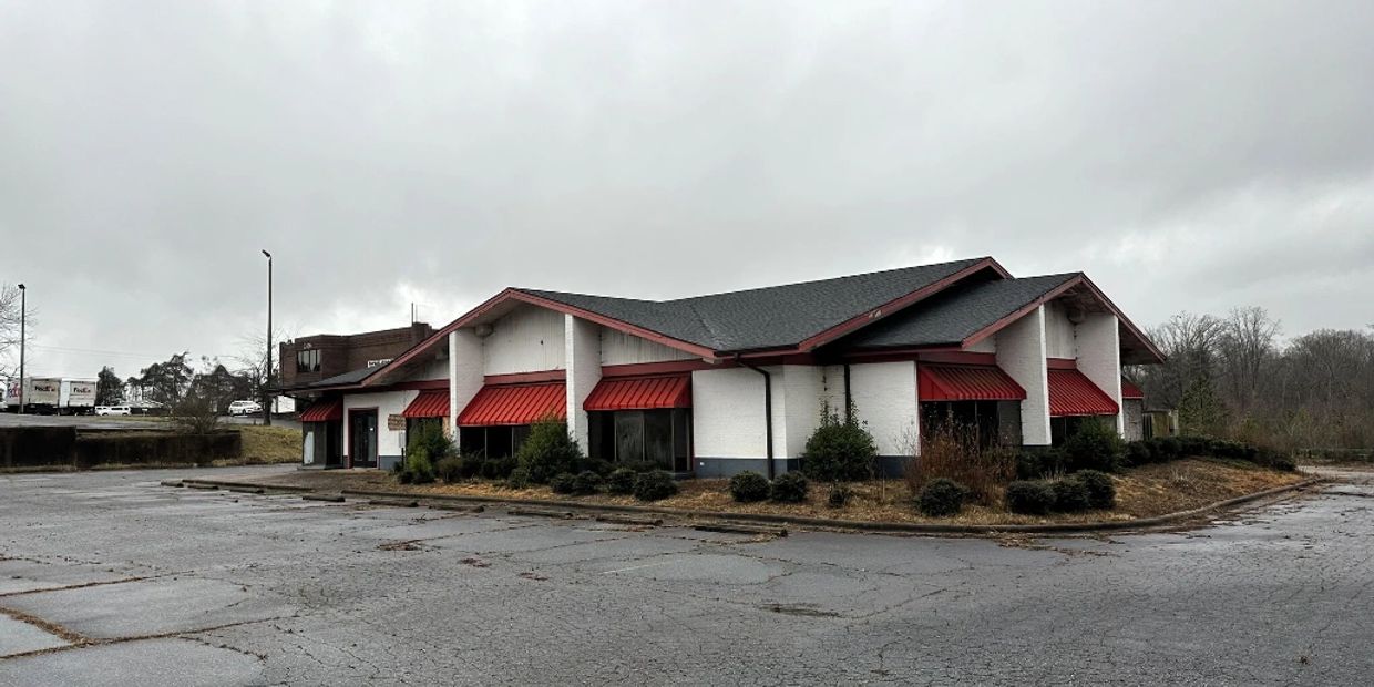 Empty building with red awnings on a cloudy day.
