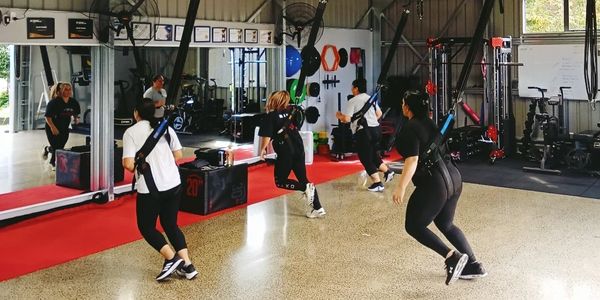 Group workout session using resistance bands in a gym.