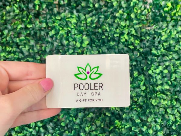 A person handing a card ofpoolers day spa.