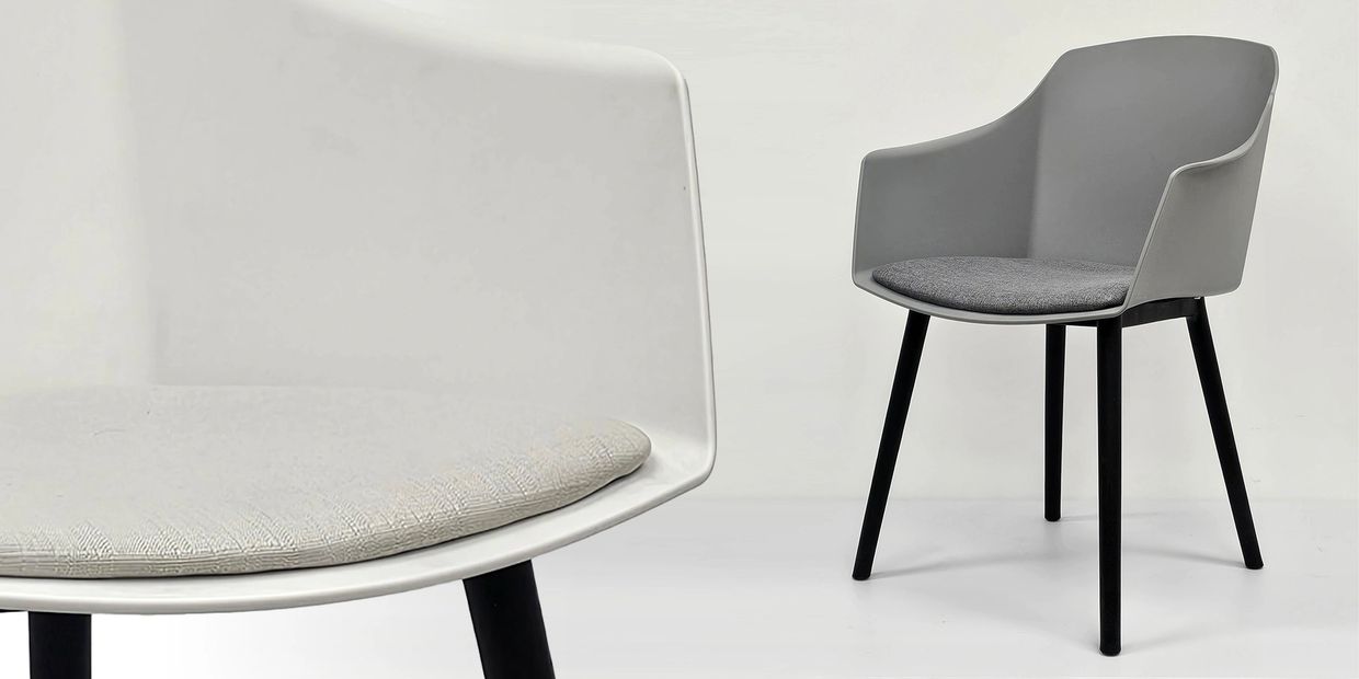 Two modern chairs with gray cushions and black legs on a white background.