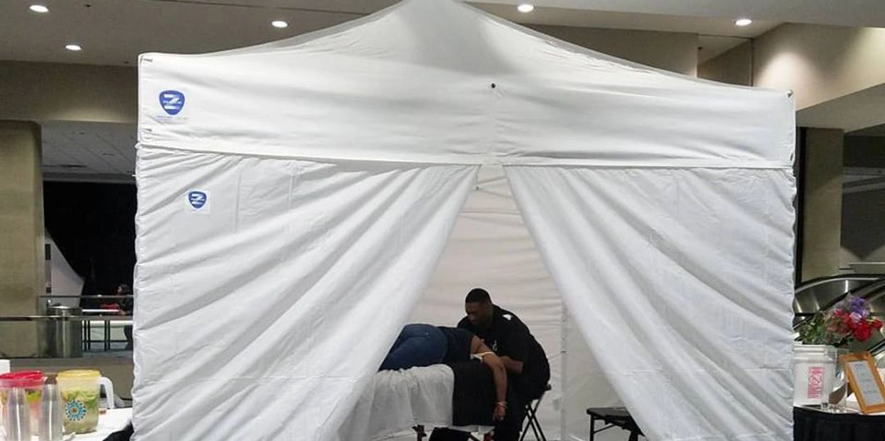 Person receiving treatment in a white tent.