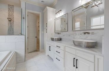 Modern bathroom with dual vessel sinks and marble accents.