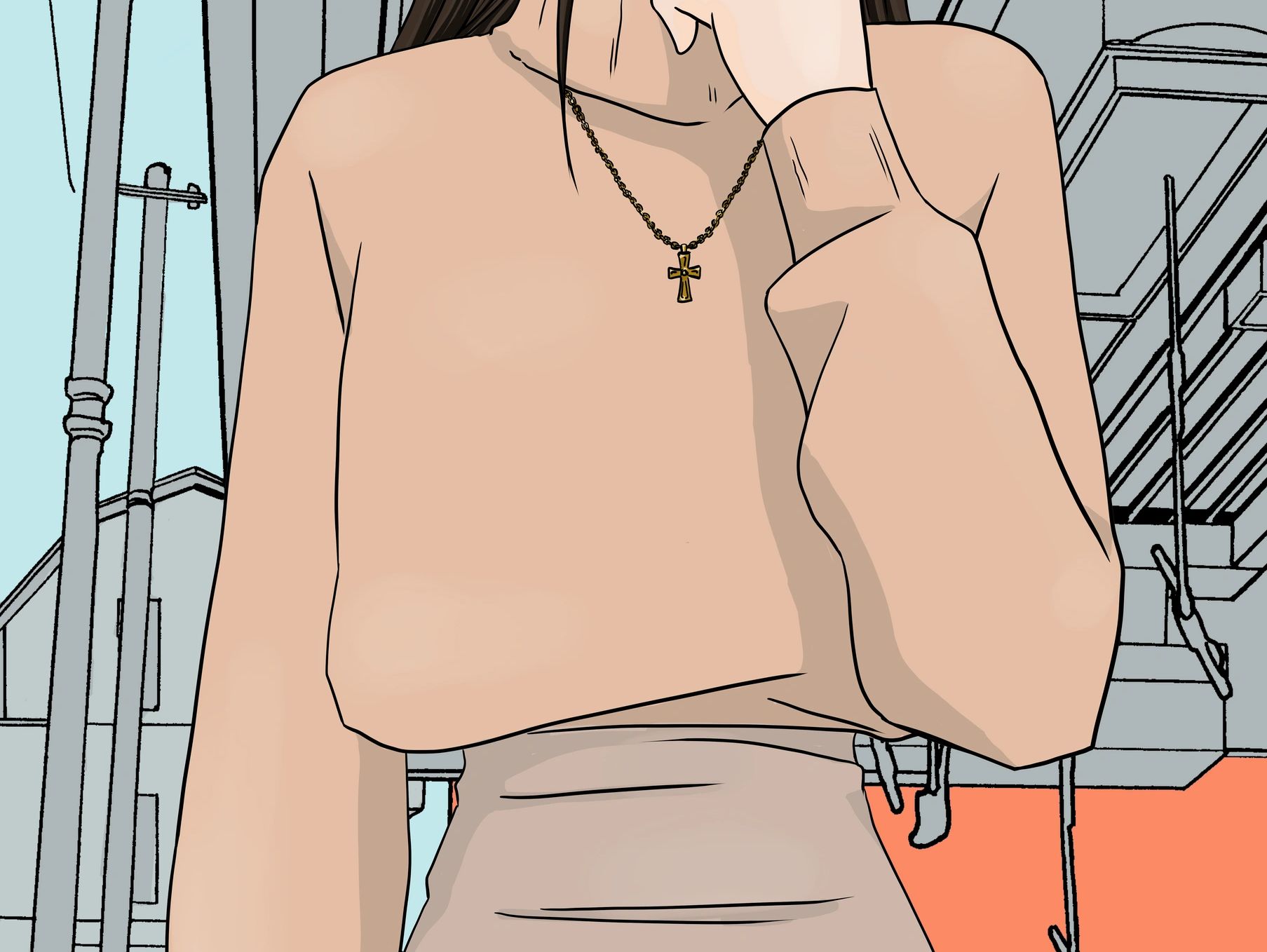 A person wearing a peach sweater and cross necklace in an urban setting.