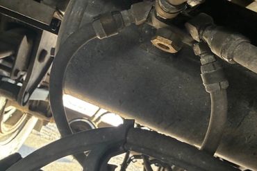 Close-up of vehicle air brake system components and hoses.