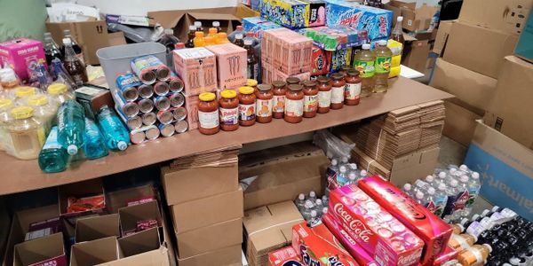 Shelves filled with assorted beverages and canned goods in a storage area.