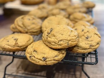 Freshly baked chocolate chip cookies cooling on a wire rack.