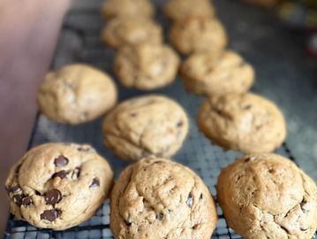 Freshly baked chocolate chip cookies cooling on a wire rack.