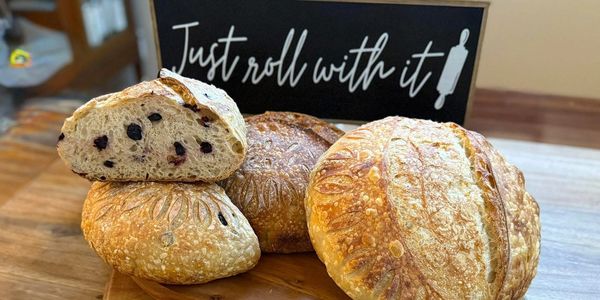 Artisan breads with blueberries and lemons on a wooden table.