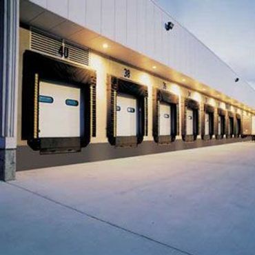 Row of loading docks at an industrial building under bright lights.