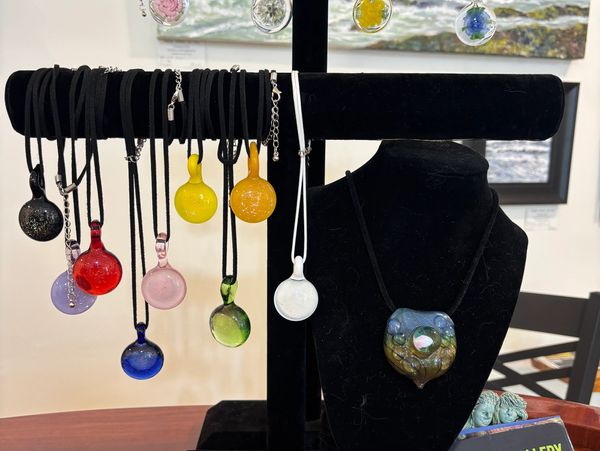 Handcrafted glass pendants by Hobbs glass from Hope BC, featuring flame worked, colorful designs on
