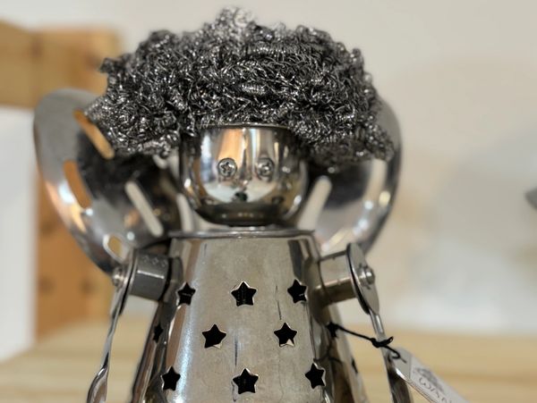 Metal robot sculpture with curly texture, hair star shaped cut outs and shiny chrome finish created