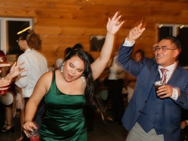 Two people dancing energetically at a lively party indoors.