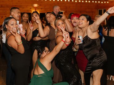 Group of friends celebrating and posing with peace signs at a lively party.