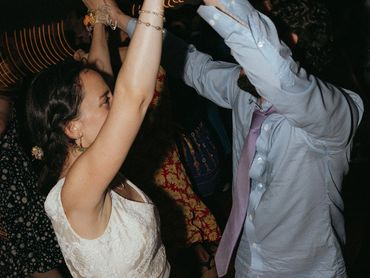 Couple dancing joyfully with hands raised at a lively event.