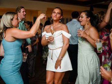 Women dancing and enjoying drinks at a lively party.