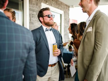 Men in suits enjoying drinks and conversation at a social event.