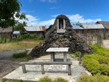 A small stone monument with benches outdoors.