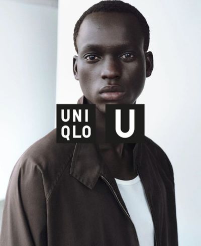 Fashion portrait of a man wearing a dark jacket and white shirt with UNIQLO U logo.