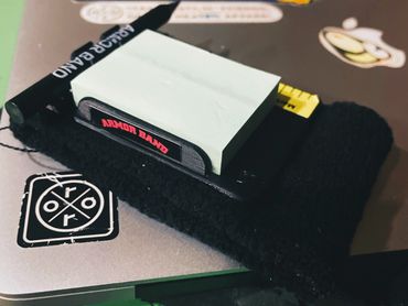 A black Armor Band with sticky notes and a pen on a laptop.