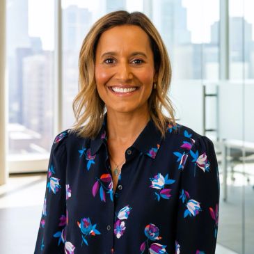 Smiling woman in floral blouse in an office.
