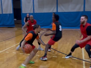 Young basketball players in action on an indoor court during a game.