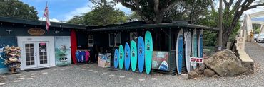 exterior of Blue Planet surf shop in Haleiwa with display of colorful rental surfboards