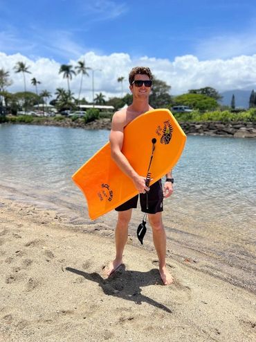 man holding body board on the beach