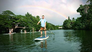 Robert Stehlik paddling on the Anahulu River with Rainbow and rope swing in background