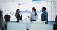 Business team discussing data charts in a modern office.