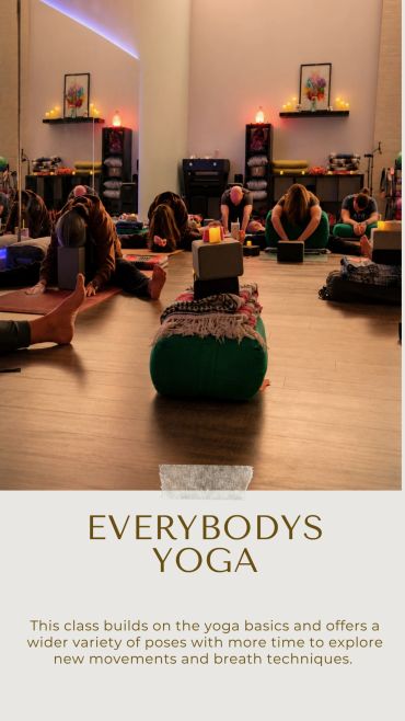 Group yoga session in a cozy studio with candles and props.