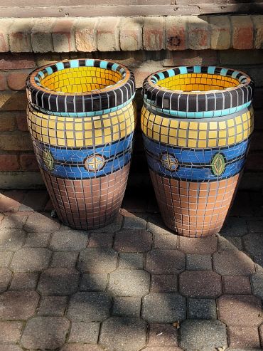 Pair of handcrafted terracotta planters featuring antique Malibu tile and geometric Mediterranean-inspired mosaic designs.
