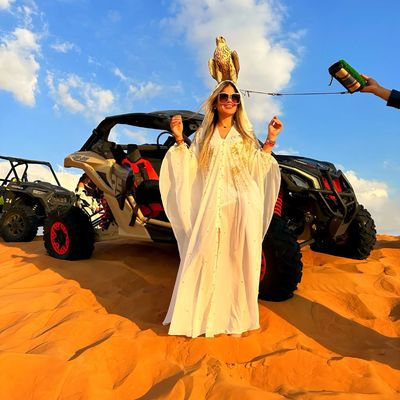 a lady standing next to a dune buggy in Dubai