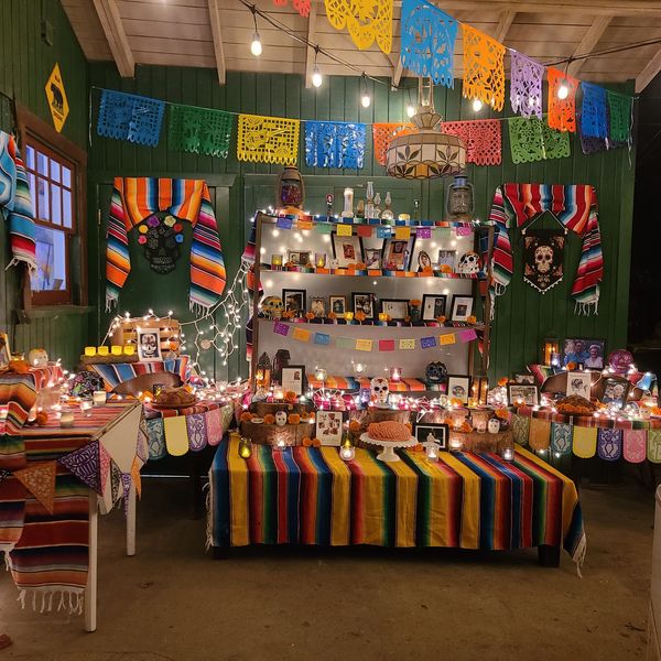 Traditional Día de los Muertos altar with candles, photos, and colorful decorations.