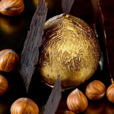 Product image: Noisette dessert, our famous, gold-covered hazelnut chocolate dessert. Dessert is sha