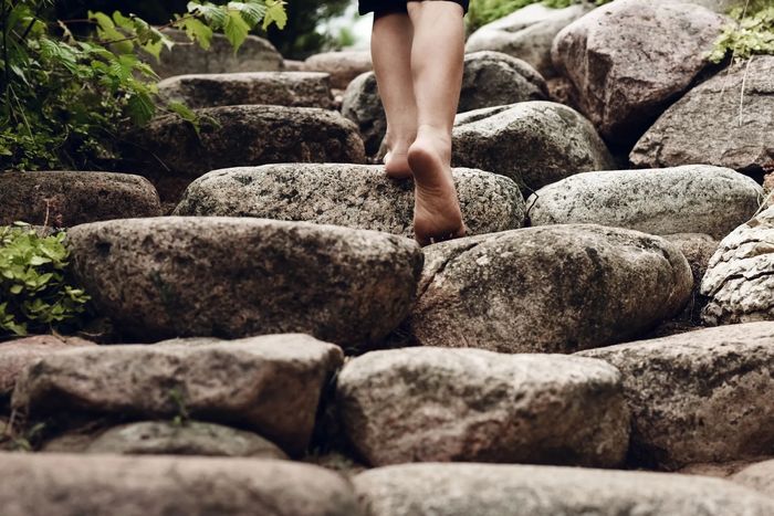 A person climbing rocks to a higher level