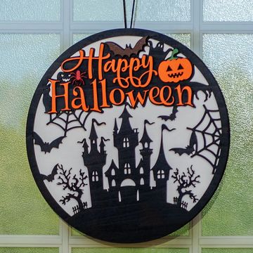 A Halloween-themed hanging decoration with a haunted castle and festive text.