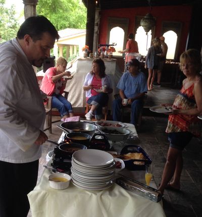 People enjoying a casual meal gathering with food dishes and plates.