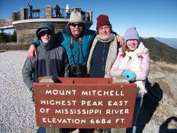 Family standing at the peak of Mount Mitchell near laurelwood Lodge Lake Lure NC