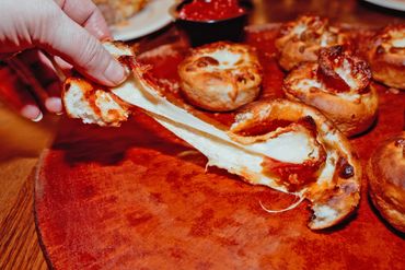 An individual pulling apart one of the Pizza Blossoms offered at Wood Chipper Pizza