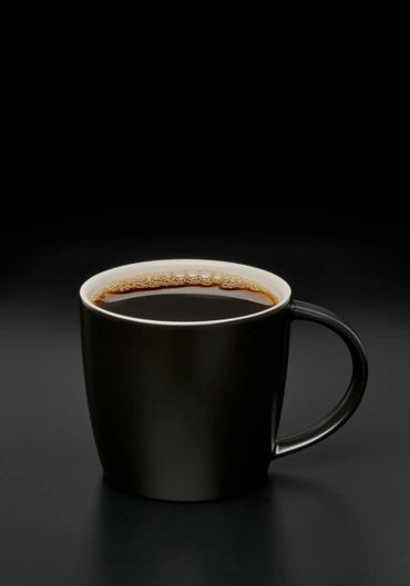 Black coffee in a sleek black mug on a dark surface.