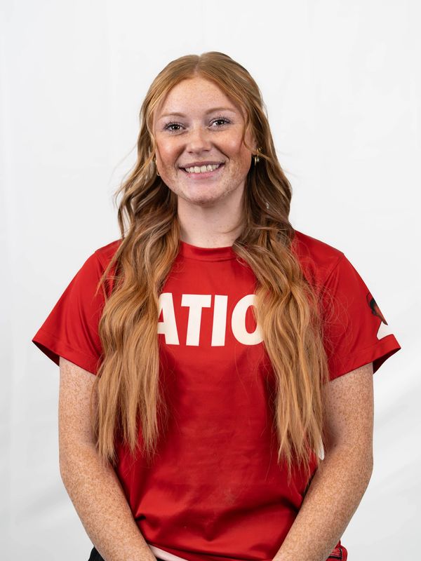 Smiling young woman with long red hair in a red T-shirt.