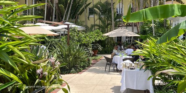 Path to the restaurant at Cafe Boulud, Palm Beach, people sitting outside and eating in the garden