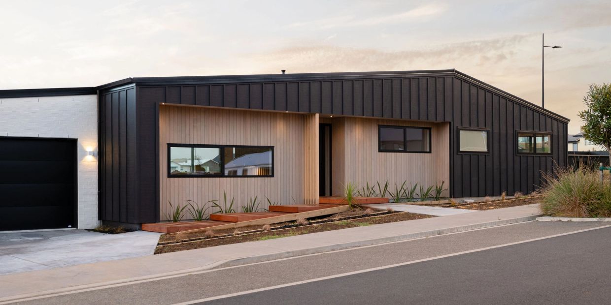 Modern house with black and wood panel exterior.