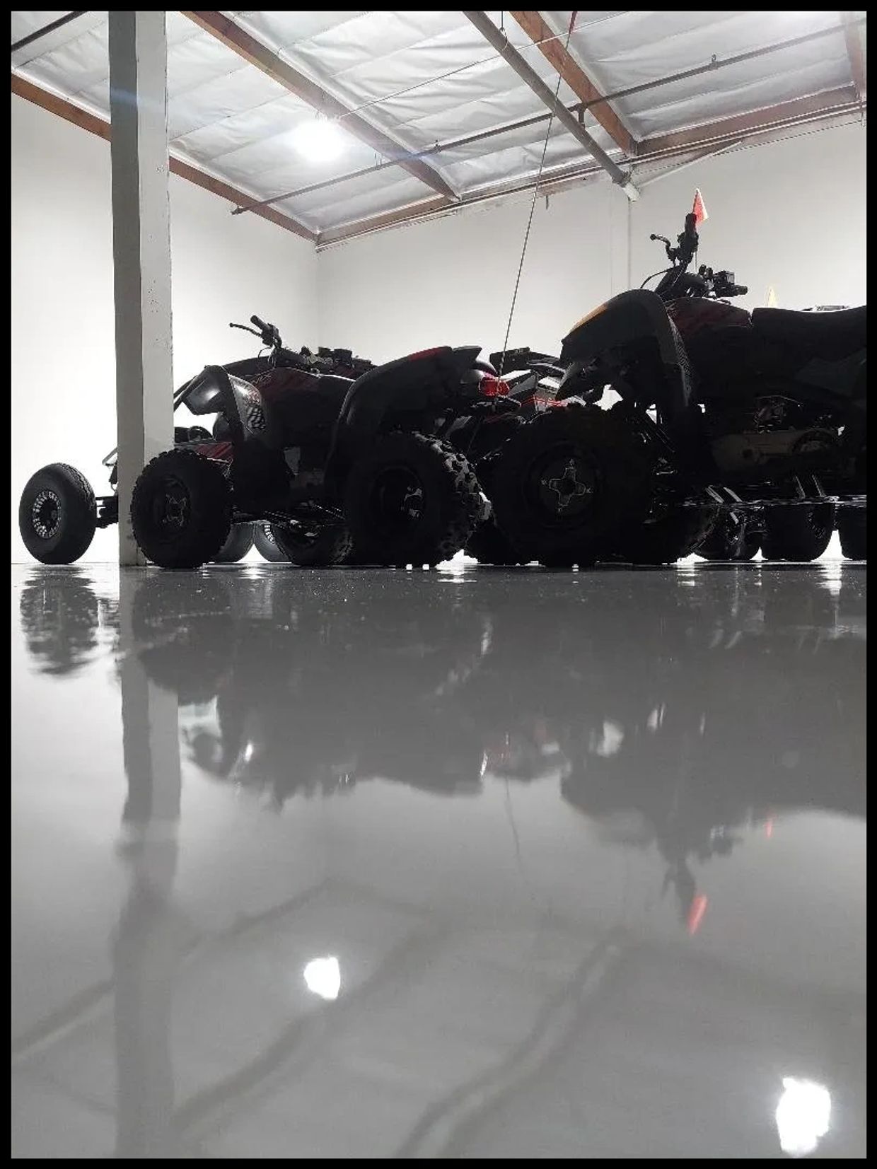 Recreational equipment sitting on a glossy epoxy floor in a warehouse.