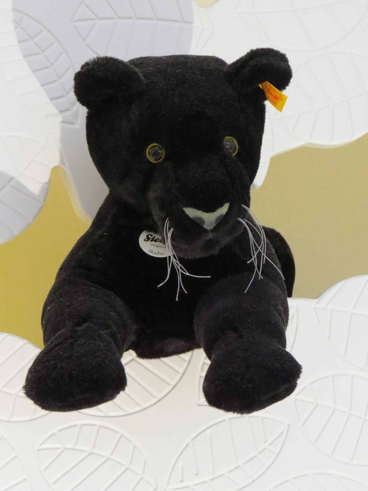 Plush black panther toy with yellow eyes and white whiskers.