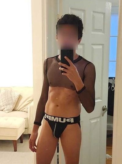 Person taking mirror selfie wearing black mesh top and black PUMP underwear.