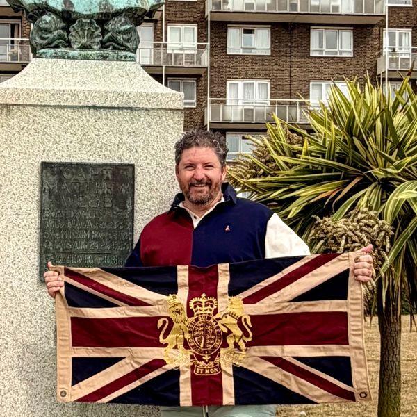 Man holding a historic British flag.