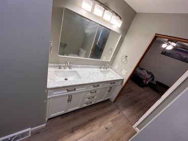 Modern bathroom vanity with double sinks and a large mirror.