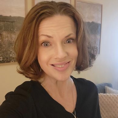 Smiling woman with light brown hair in a cozy room.