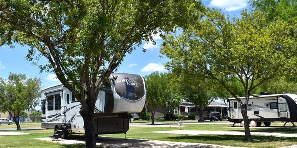 RV camping: North Point RV parked at a campground with trees and green grass.
